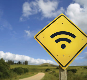 Internet access in remote zone, power of technology concept. Road sign with wifi signal icon on rural environment